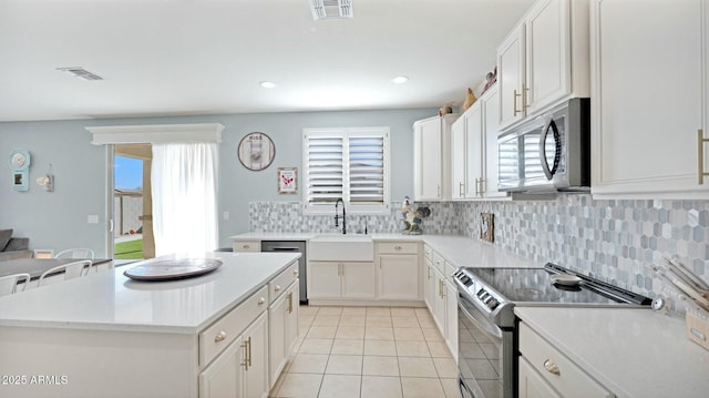 kitchen with a center island, a healthy amount of sunlight, sink, and appliances with stainless steel finishes