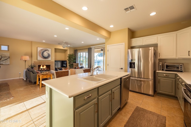 kitchen featuring gray cabinetry, a tile fireplace, sink, white cabinetry, and appliances with stainless steel finishes