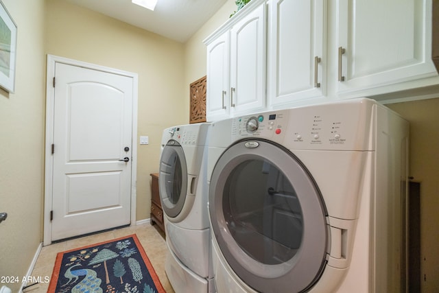 laundry room featuring cabinets, independent washer and dryer, and light tile patterned floors