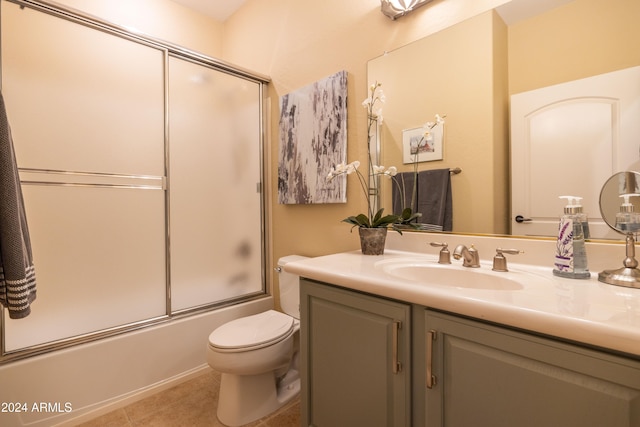 full bathroom with vanity, enclosed tub / shower combo, toilet, and tile patterned floors