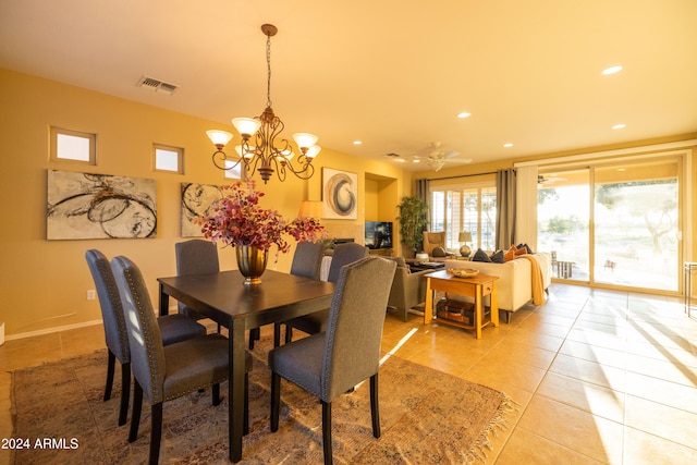 dining area with ceiling fan with notable chandelier and light tile patterned floors