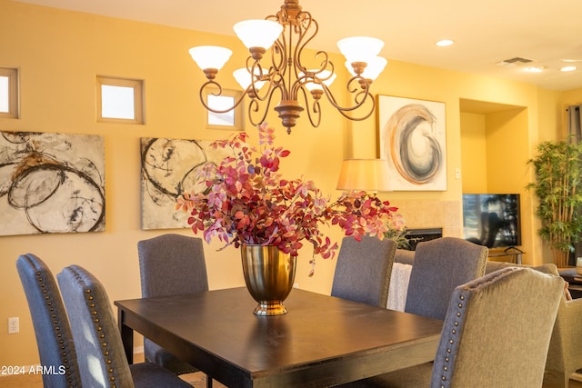 dining space featuring an inviting chandelier and a tile fireplace