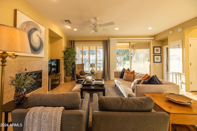 living room with light tile patterned floors, a fireplace, and ceiling fan