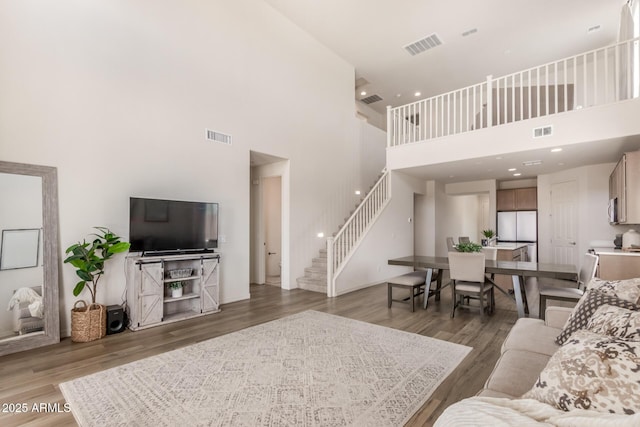 living room featuring light wood-type flooring and a towering ceiling