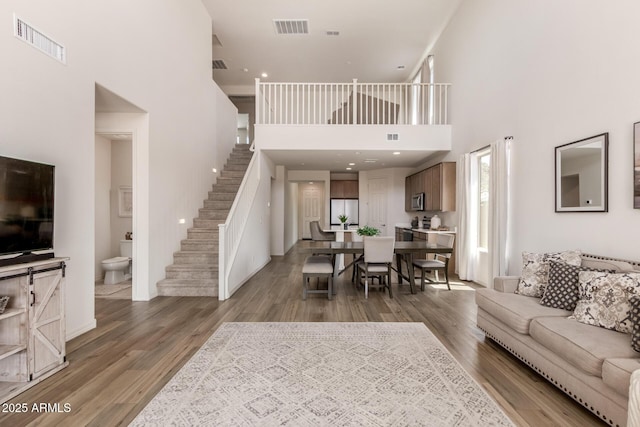 living room featuring a high ceiling and hardwood / wood-style floors