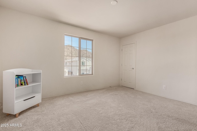 unfurnished room featuring light carpet