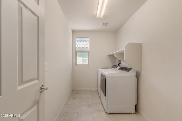 laundry area featuring light tile patterned floors and washer and clothes dryer