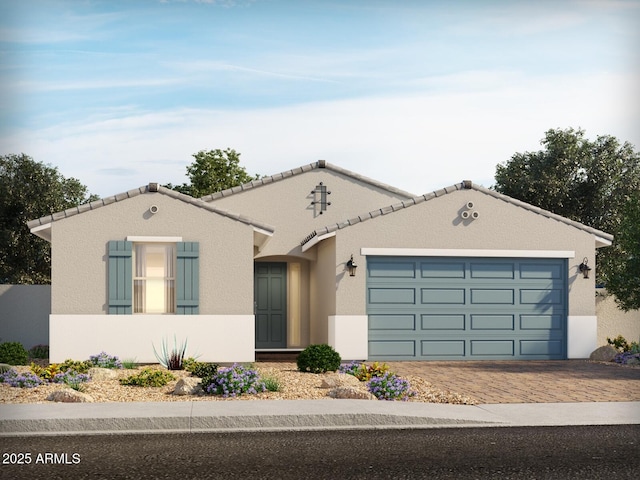 17530 W Woodlands Ave, Goodyear, AZ 85338 - mediterranean / spanish house featuring decorative driveway, a garage, stucco siding, and a tiled roof