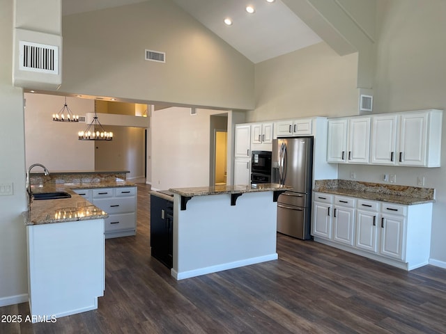 kitchen with visible vents, high vaulted ceiling, white cabinets, a sink, and appliances with stainless steel finishes