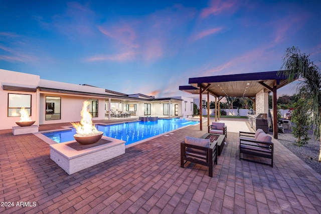 pool at dusk featuring a patio area and a fire pit