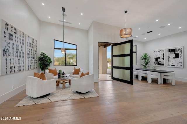 living room featuring a towering ceiling and light wood-type flooring