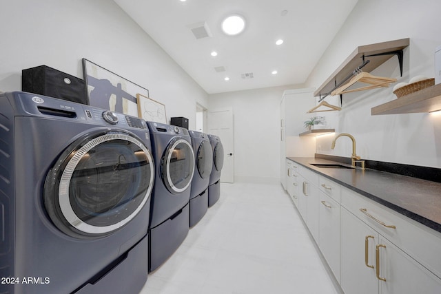 laundry room with cabinets, washer and dryer, and sink