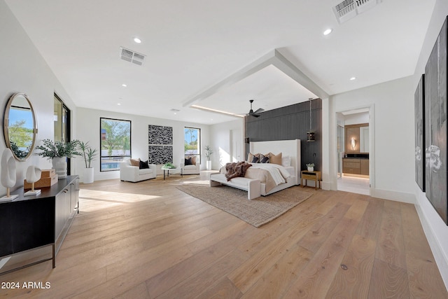 bedroom with light hardwood / wood-style flooring, ensuite bath, and ceiling fan