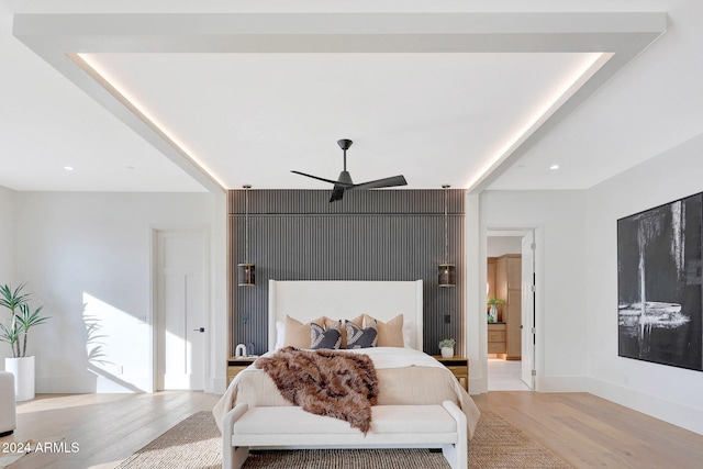 bedroom with ensuite bath, light wood-type flooring, and ceiling fan