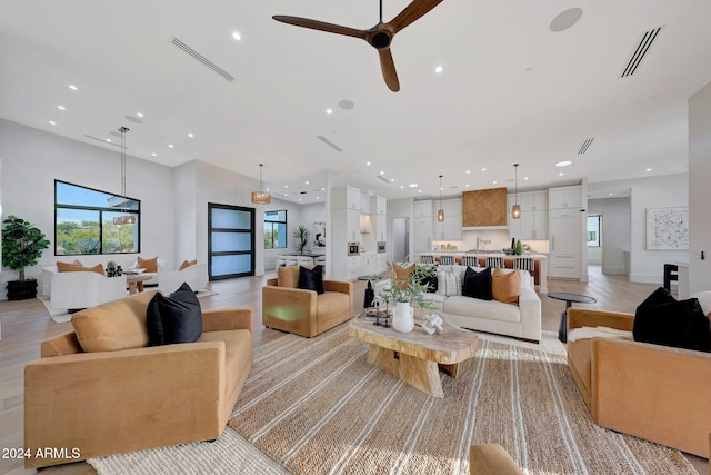 living room with light hardwood / wood-style floors and ceiling fan