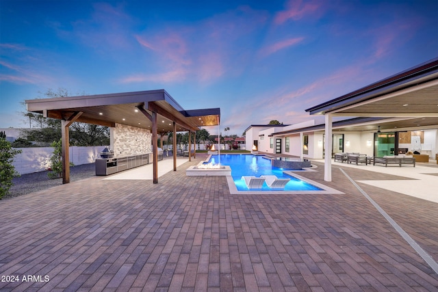 pool at dusk featuring a patio area