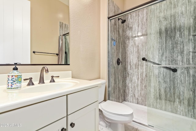 bathroom with toilet, tiled shower, and vanity