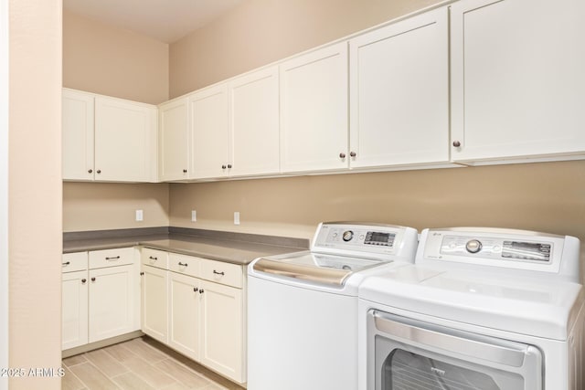 laundry area with washing machine and dryer and cabinets