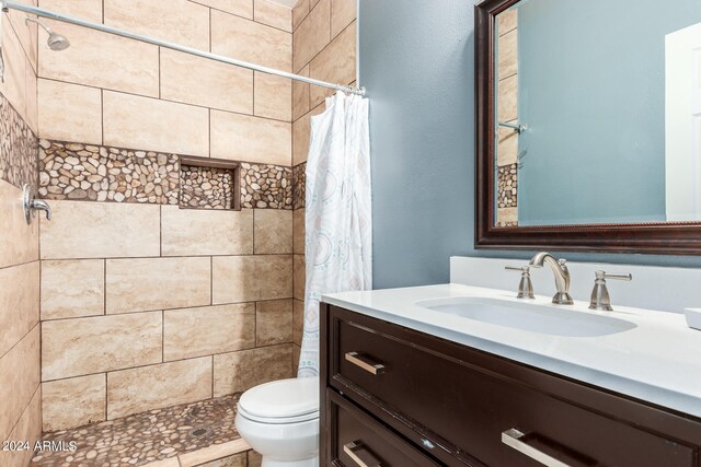 bathroom with a shower with shower curtain, vanity, and toilet