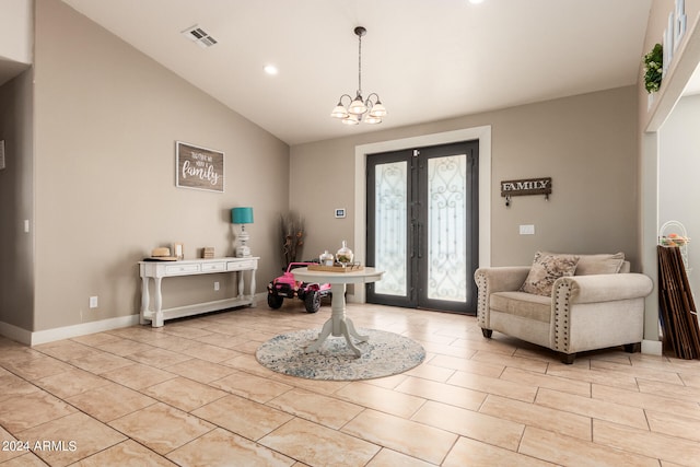 entrance foyer featuring lofted ceiling, an inviting chandelier, and french doors