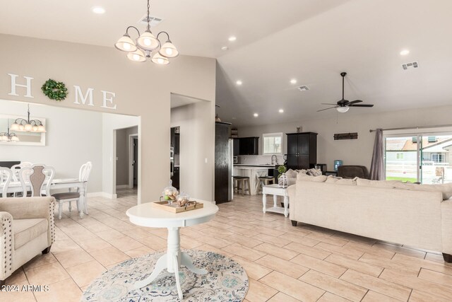 living room with ceiling fan with notable chandelier, light tile patterned floors, and high vaulted ceiling