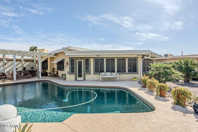 view of swimming pool with a sunroom, a pergola, and a patio