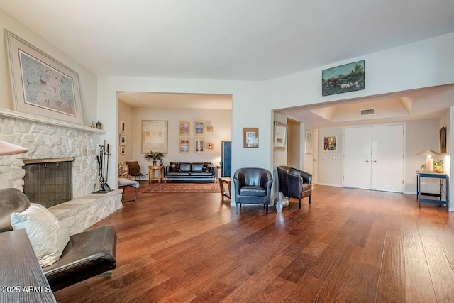 living room featuring wood-type flooring and a fireplace