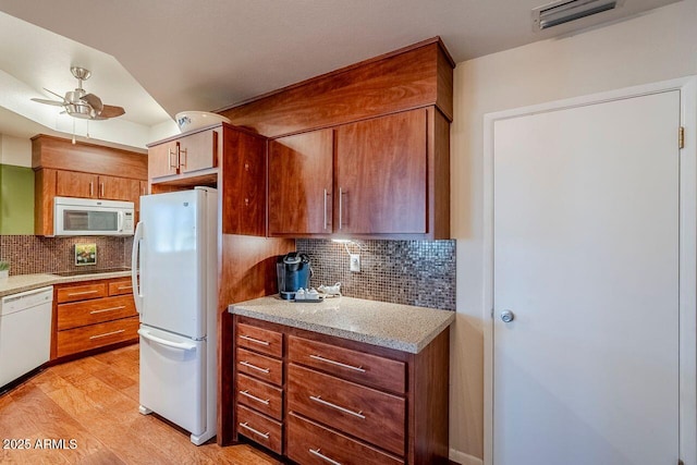 kitchen with tasteful backsplash, ceiling fan, light wood-type flooring, and white appliances