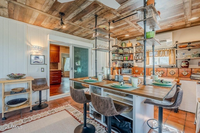 dining room with light tile patterned flooring, a wall mounted AC, and wooden ceiling