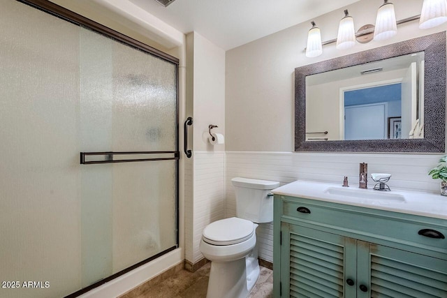 bathroom featuring vanity, a shower with door, and toilet