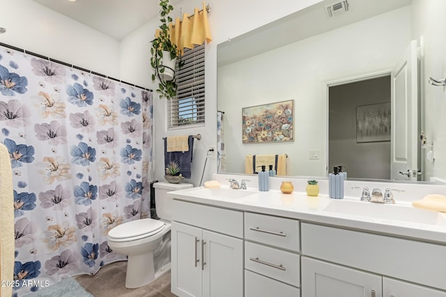 bathroom with tile patterned floors, vanity, toilet, and curtained shower