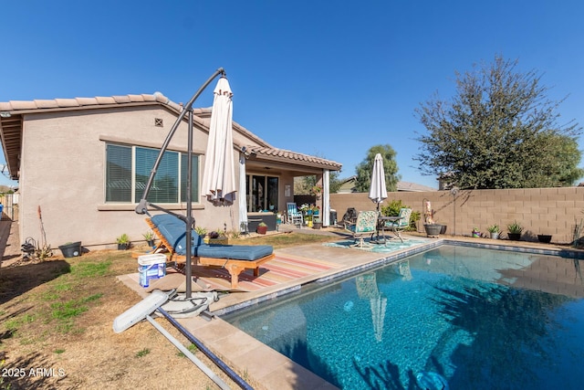 back of property featuring a fenced in pool and a patio area