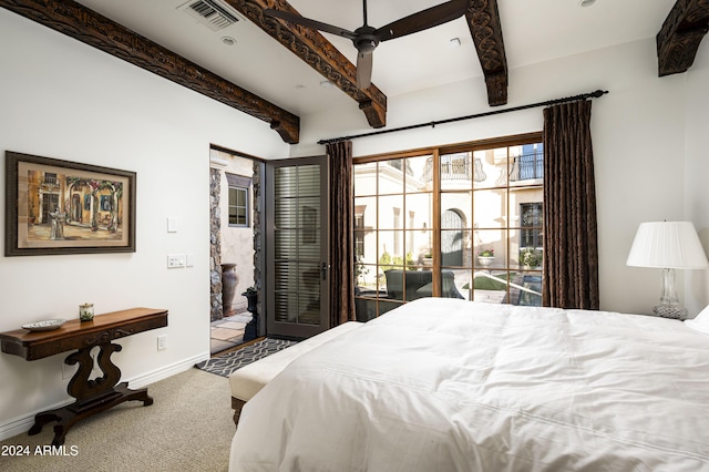 carpeted bedroom featuring beamed ceiling and ceiling fan