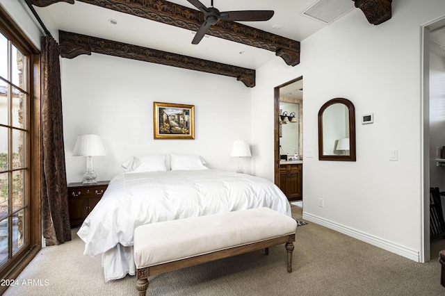 bedroom with carpet flooring, ensuite bathroom, beamed ceiling, and ceiling fan