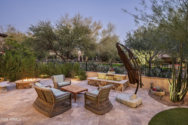 patio terrace at dusk featuring an outdoor living space with a fire pit