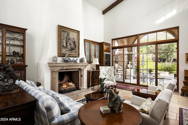 living room featuring beamed ceiling and a towering ceiling