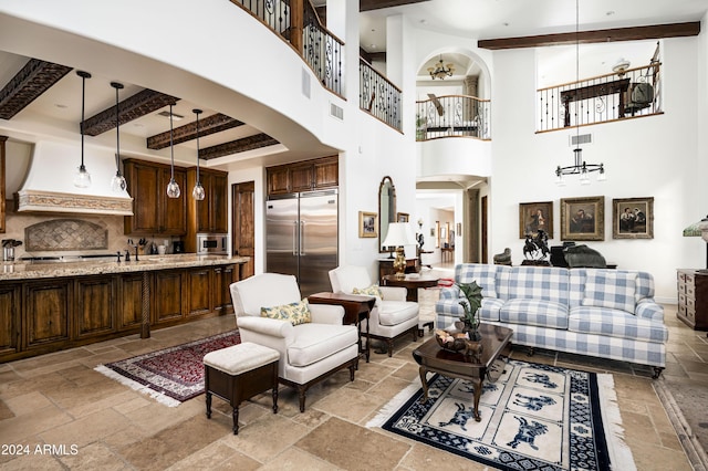 living room with beam ceiling and a towering ceiling