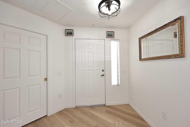 foyer entrance featuring light wood-style floors and baseboards