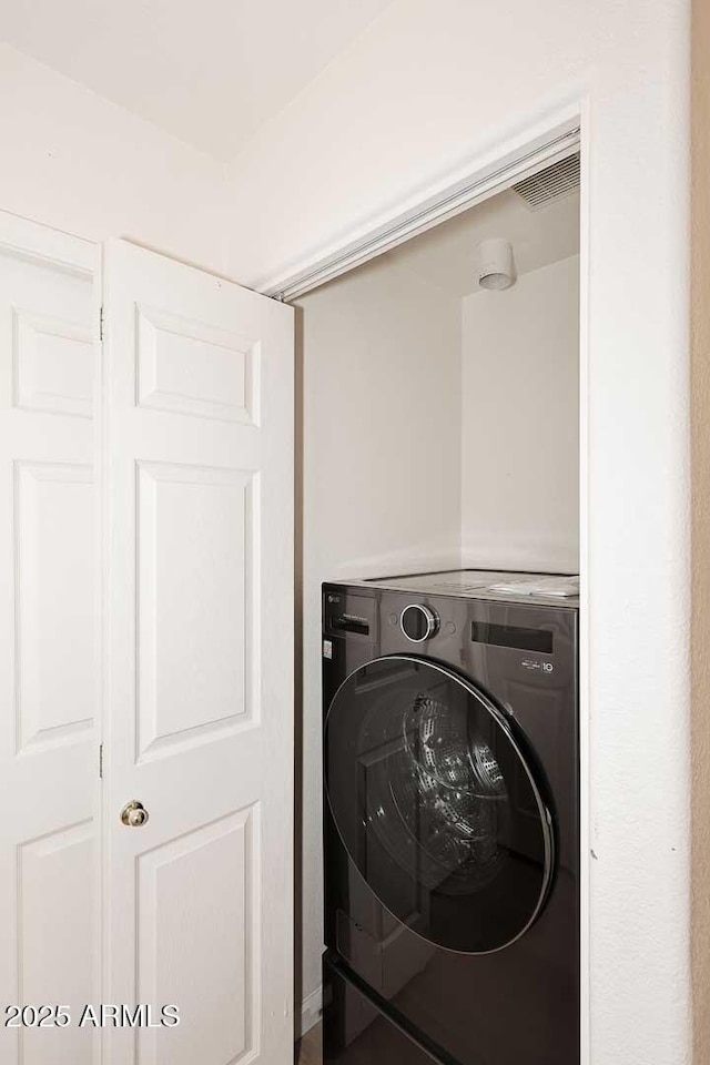 laundry room featuring laundry area, visible vents, and washer / clothes dryer