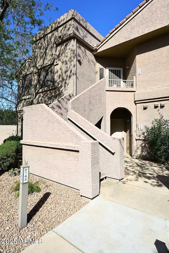 exterior space with a patio, a tiled roof, a balcony, and stucco siding