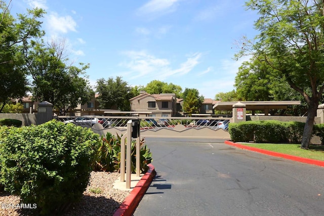 view of road with curbs and a gated entry