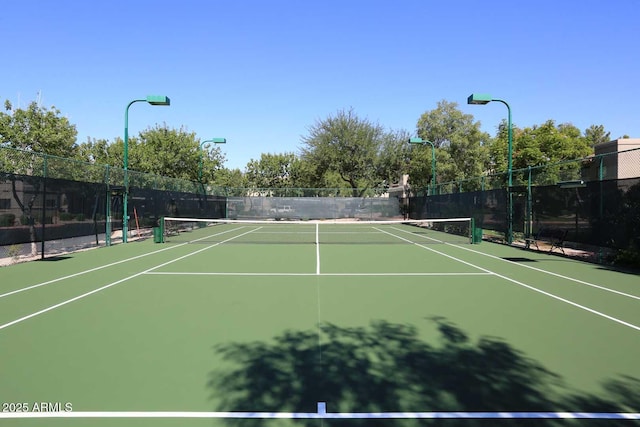 view of tennis court featuring fence