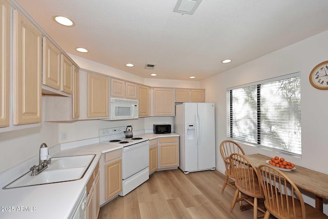 kitchen featuring white appliances, visible vents, light countertops, and a sink