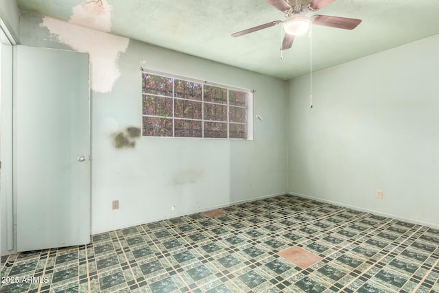 empty room featuring baseboards and a ceiling fan