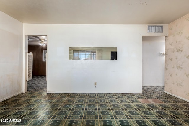empty room featuring tile patterned floors, visible vents, wallpapered walls, and a ceiling fan