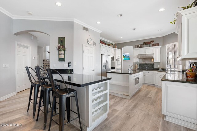 kitchen featuring sink, white cabinetry, a kitchen island with sink, light hardwood / wood-style floors, and stainless steel appliances