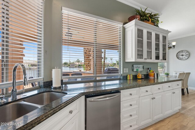 kitchen with crown molding, white cabinets, a breakfast bar area, and light hardwood / wood-style floors