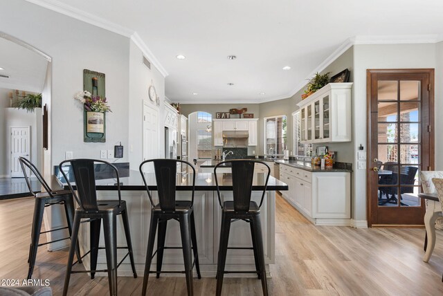 dining area with crown molding, light wood-type flooring, and a chandelier