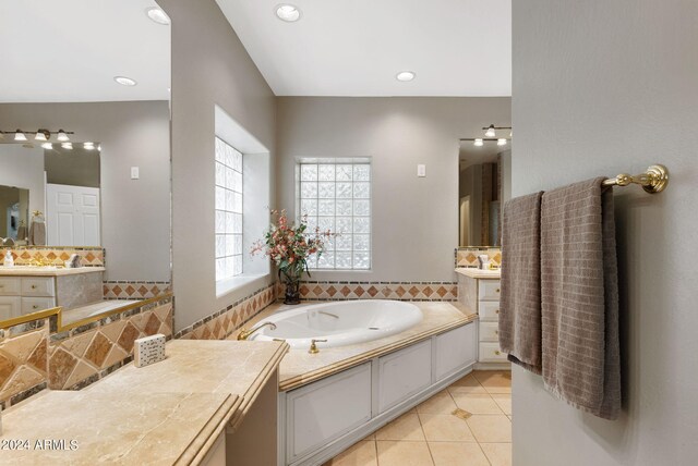 bathroom featuring plenty of natural light, tile patterned floors, a bathtub, and vanity