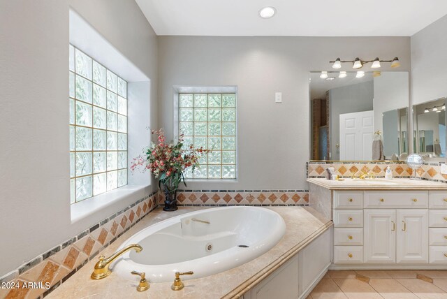 bathroom with vanity, a bathtub, and tasteful backsplash